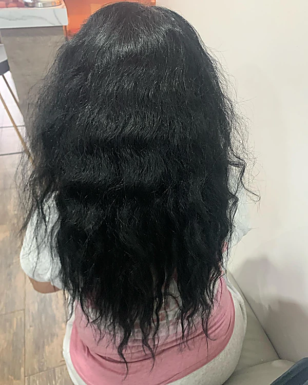 Cabello largo negro, ondulado y esponjado, visto de espalda, antes del tratamiento